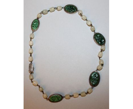 A GOOD QUALITY CHINESE JADE & SILVER-METAL NECKLACE, with pierced oval apple-green floral carvings divided by groups of white