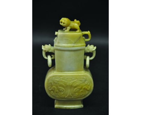 A CHINESE JADE-LIKE VASE OF ARCHAIC FORM, with double ring handles, the sides decorated with taotie masks, the stone of an un