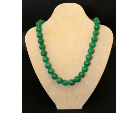 A CHINESE GREEN JADE-LIKE NECKLACE, composed of spherical beads, approx. 22.5in long.