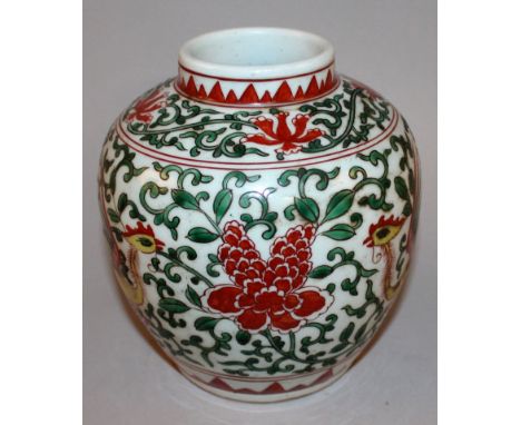 A CHINESE WUCAI PORCELAIN PHOENIX JAR, the sides decorated with two opposing phoenix divided by a large head of scroll-stemme