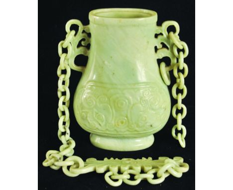 A 19TH CENTURY CHINESE JADE-LIKE HANGING VASE, the pale green stone with darker striations, the sides of the flattened ovoid 