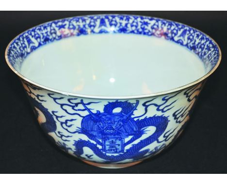 AN UNUSUAL CHINESE 17TH/18TH CENTURY BLUE & WHITE PORCELAIN BOWL, the sides painted with repeated coiled dragons clasping an 