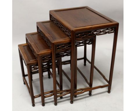 A GOOD NEST OF FOUR 19TH CENTURY CHINESE CARVED HARDWOOD TABLES, each with a pierced scroll frieze, the largest 19in x 13.9in
