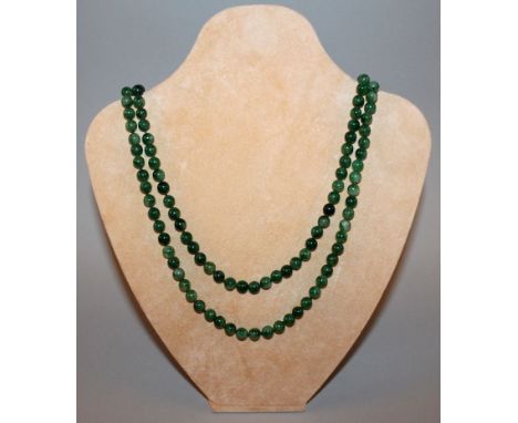 A LONG CHINESE GREEN JADE-LIKE NECKLACE, composed of spherical beads, approx 52in long.