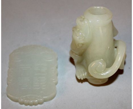 A SHAPED CHINESE JADE-LIKE PENDANT, decorated with a boy on an elephant and with a seal mark, 2.25in high; together with a ja