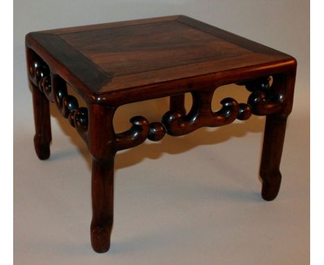 A 19TH CENTURY CHINESE CARVED HARDWOOD LOW TABLE, the sides well carved with a pierced scroll frieze, 13.6in square & 10.15in