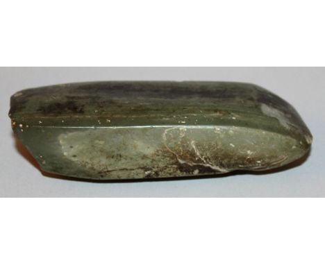 A CHINESE NEOLITHIC JADE AXE, the angular stone of predominantly green tone with darker inclusions, 4.5in long.