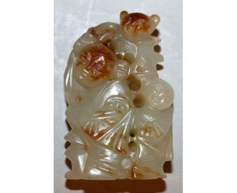 A SMALL CHINESE CELADON GREEN JADE-LIKE CARVING OF THREE BOYS, the stone with brown inclusions, 1.75in high.