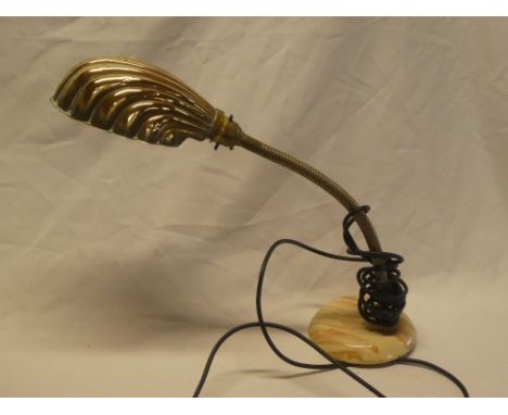 An old brass scallop-shaped adjustable desk lamp with ceramic base