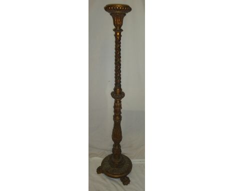 An old gilt painted candle stand/lamp base with raised scroll decoration on circular base with paw feet, 59½" high