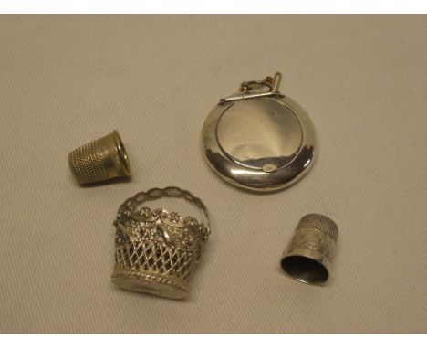 A George V silver circular suspended compact, Birmingham marks 1921, a small silver thimble, ornate filigree basket, etc