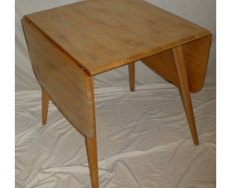 A 1960/70's Ercol pale elm drop leaf rectangular dining table on tapered legs