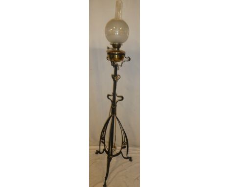 An Art Nouveau painted iron adjustable oil lamp standard supporting a brass oil lamp with etched glass shade (converted to el