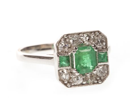 ART DECO EMERALD AND DIAMOND RING, the octagonal bezel set with a step cut emerald flanked by two square emeralds, the emeral