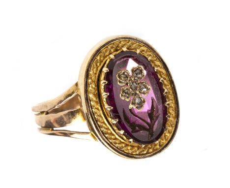 LATE VICTORIANGEM AND DIAMOND SET RING, set with an oval faceted pink to red gem with overlaid diamond set clover motif, on t