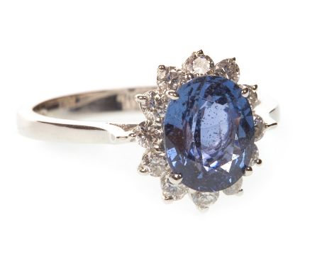 SAPPHIRE AND DIAMOND RING, the central oval sapphire 8x6mm, within a round brilliant cut diamond border, in eighteen carat go