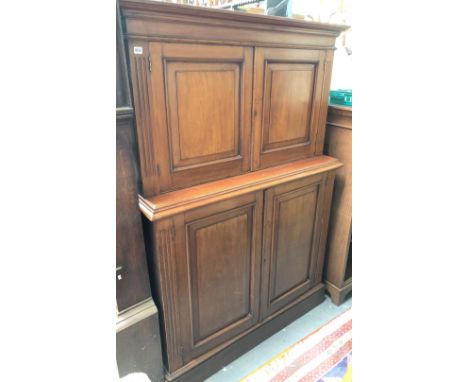 A 19th century mahogany two section hall cupboard, the top with fielded panelled cupboard doors enclosing an adjustable shelf