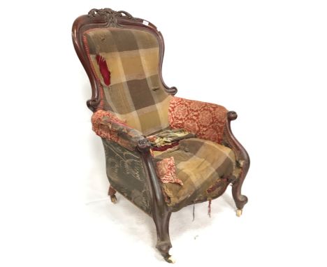 A Victorian mahogany framed gentlemans salon chair, the back with foliate scroll carved and pierced top rail over scroll carv