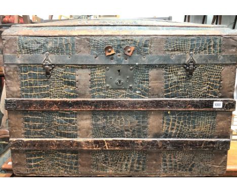 A wood and copper bound dome lidded trunk with embossed faux crocodile skin covering and with leather carrying handles, width