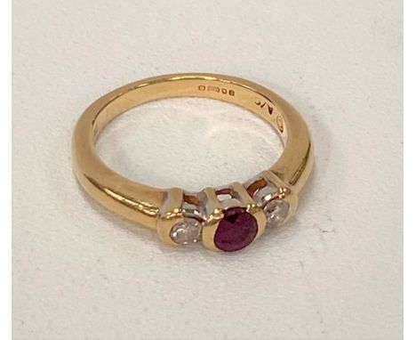 A modern 18ct hallmarked gold, diamond and ruby three stone ring, the central ruby of 0.25ct spread approx., the diamonds of 