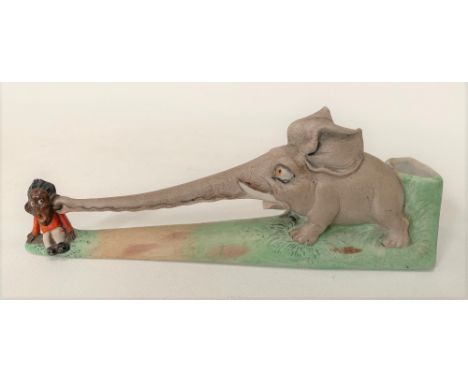 Unusual 1920s painted bisque porcelain spill vase modelled as an elephant pinching the ear of a boy with his trunk, length 17