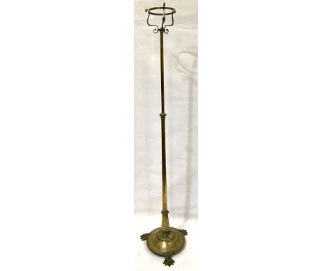 An early 20th century brass telescopic standard lamp for an oil lamp, the top with circular 6in aperture with three scroll su