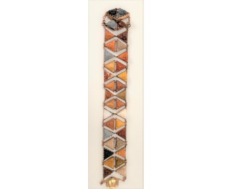 A 19th century rose gold bracelet set with two rows of triangular carved lava mask panels, length 18cm (one panel missing). 