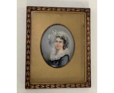 A porcelain printed and painted oval panel decorated with a girl, 8 x 6.5cm within a gilt mount and gilt gesso frame.