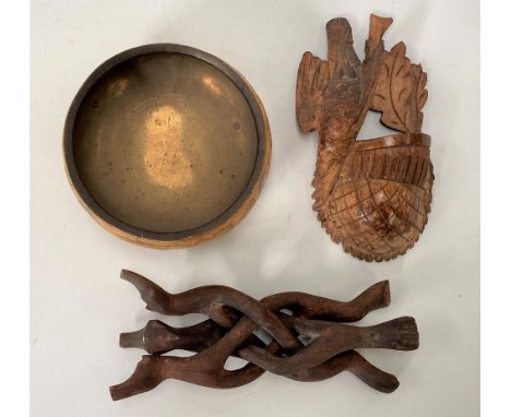 A Black Forest pine wall pocket carved with a bird, height 15cm; together with a papier mache brass lined bowl upon carved tr
