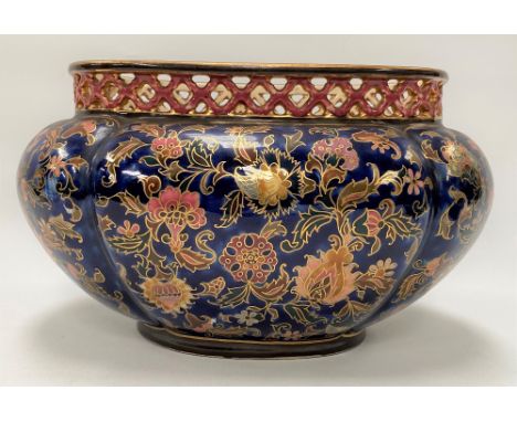 A Zsolnay Pecs oval lobed jardinière with pierced rim and painted with foliate scrolls with gilded highlights upon a cobalt b
