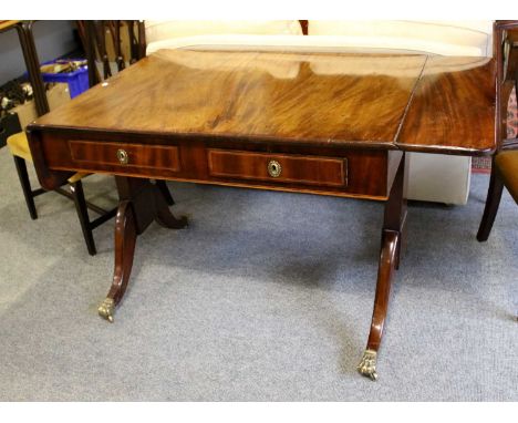 A George III Mahogany Sofa Table, with brass paw feet moving on castors, 149cm (open) by 82cm by 78cm