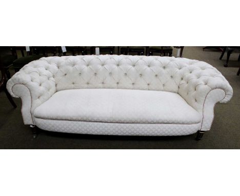 An Early Victorian Chesterfield Sofa, with cream coloured upholstery, raised on parcel-gilt black painted legs of tapering fl