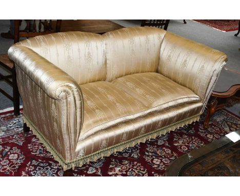 A 19th/20th Century Howard Style Two-Seater Sofa, on short mahogany legs and castors, covered in a silk fabric, of small size