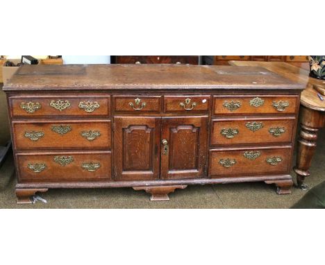 An 18th Century Oak Dresser Base, with cross-banded drawer fronts and moulded panel doors, 196cm by 50cm by 83cmThe top of tw