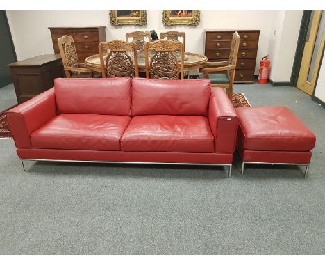 A red leather two seater settee, width 206 cm, with matching footstool 