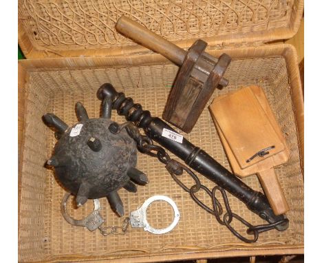 Wooden mace, rattle, clap boards and handcuffs in a picnic hamper