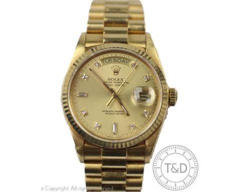 A gentleman's 18ct yellow gold Rolex Oyster perpetual day-date wristwatch, the circular face with fluted bezel, enclosing cha