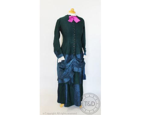 A dark green wool and silk mix dress, circa 1880, with button fastening to the front and pink bow to the collar, with teal si