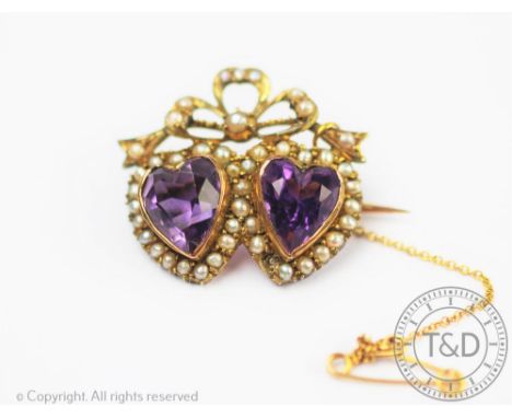 A Victorian amethyst and seed pearl set double heart brooch, designed as two amethyst hearts within a surround of seed pearls