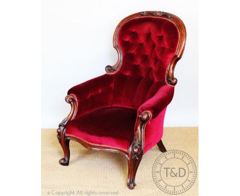 A Victorian carved mahogany salon chair, with button back upholstery, on cabriole legs and scroll feet, 104.5cm H