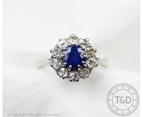 An untested sapphire and diamond circular cluster ring, the central sapphire within ten claw setting and surrounded by ten ol