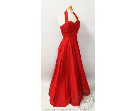 A vintage 1950's red taffeta evening gown, the a-line dress with a halter neckline and ruched detailing to the bodice, with f