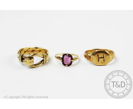 A 9ct yellow gold buckle ring, a 9ct gold signet ring incised 'H' and a further ring stamped '9ct' set with an amethyst colou