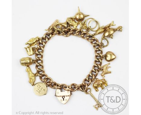 A Victorian 9ct yellow gold curb link bracelet, hung with numerous charms, including; an oil lamp, a heart, Sputnik, an eleph