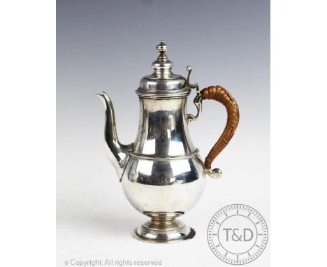 A silver coffee pot, Wilson &amp; Sharp, Birmingham 1912, of baluster form with turned cover finial and scroll wicker handle,