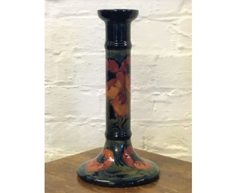 A Moorcroft candlestick converted to a lamp base, in a poppy pattern, the slender cylindrical column raised on a spreading ci