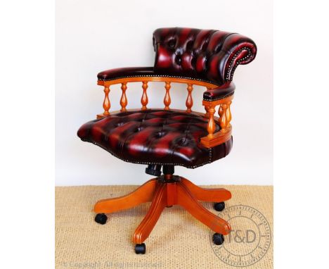 An office swivel desk chair, with button back red leatherette upholstery. 82cm H