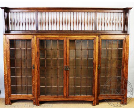 An Arts and Crafts oak bookcase in the manner of Shapland and Petter, of large proportions, with three quarter gallery top ab