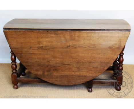 An 18th century style oak gate leg table, on turned and block legs with moulded stretchers, 76cm H x 180cm W 142cm D (size wh