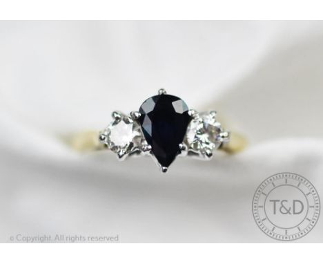 A sapphire and diamond three stone ring, the central pear shaped sapphire flanked by a brilliant cut diamond to either side, 